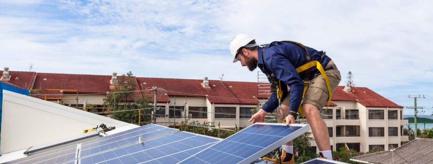 Techniker bei der Installation einer Solaranlage auf einem Hausdach zur Förderung der Solarenergie-Nutzung