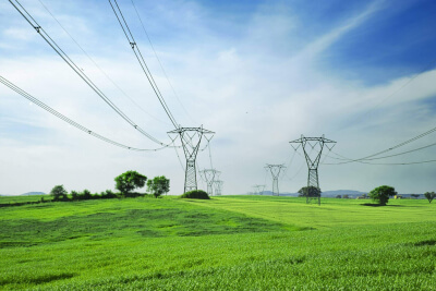 Stromtrasse durch eine grüne Landschaft