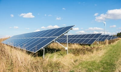 Solaranlagen und Windrad als Symbol für die fortschreitende Energiewende in Deutschland 2023