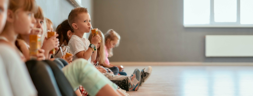 Gruppe von Kindern in einer Kita während der Pause, potenzieller Empfänger von Fördermitteln für energieeffiziente Umbauten.