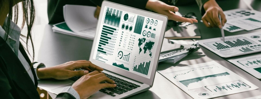 Menschen analysieren Energiestatistiken auf einem Laptop und erstellen Pläne zur Einhaltung des Energieeffizienzgesetzes